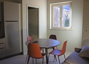 a kitchen with a table and chairs and a window at Appartamento PALE 2 posti letto in Pale