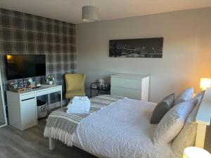 a bedroom with a bed and a desk and a television at Bragan Mountain View in Monaghan