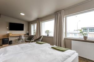 ein Schlafzimmer mit einem großen weißen Bett und Fenstern in der Unterkunft Stracta Hotel Mosfell in Hella