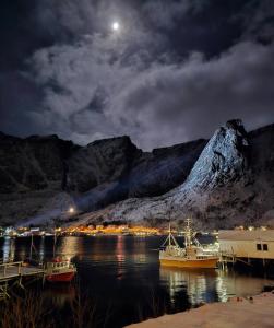 a harbor with boats in the water at night at Apartment at Lofoten. Mølnarodden. in Sund