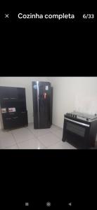 a black refrigerator and a piano in a room at Recanto do Garças in Aragarças