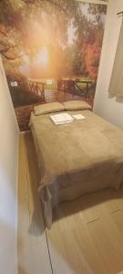 a bedroom with a bed with a painting on the wall at Casa Container em Monte Verde - 800m do Centro in Monte Verde