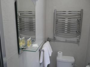 a bathroom with a glass shelf above a toilet at Desota House Bed and Breakfast in Galway +17 photos