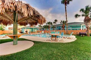 a patio with a table and chairs next to a pool at The Island Hotel Near Beach Port Aransas in Port Aransas