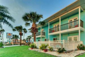 a building with palm trees in front of it at The Island Hotel Near Beach Port Aransas in Port Aransas