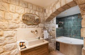 a stone bathroom with a sink and a tub at המילטון 2 - Hamilton 2 in Safed