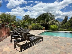a row of lounge chairs next to a swimming pool at Casa Valdres in Santa Cruz La Laguna