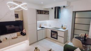 a small living room with a kitchen and a tv at Lumina Residence Našice in Našice