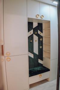 a closet with white cabinets and a green bench at Lumina Residence Našice in Našice