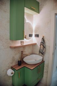 a bathroom with a green sink and a mirror at Lumina Residence Našice in Našice +10 photos