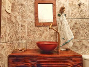 a bathroom with a bowl sink on a wooden table at Suítes Aconchego - Pousada Rústica & Café da Manhã Especial in Lençóis
