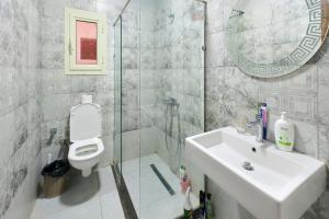 a bathroom with a sink and a toilet and a shower at 树屋民宿 in Cairo +3 photos