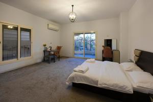 a bedroom with a bed and a desk and windows at 树屋民宿 in Cairo