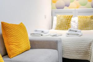 a bedroom with a bed with a yellow pillow and a chair at 1 Bed in Penzance oc-u34132 in Penzance