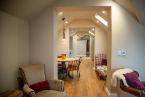 a dining room and living room with a table and chairs at Bridge House Barn in Kibworth Harcourt