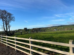 a white fence in front of a green field at Bragan Mountain View in Monaghan