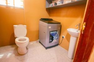a bathroom with a toilet and a sink at Classic Apartment at Tema Community 26 in Tema