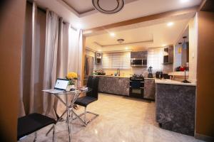 a kitchen with a table with a laptop on it at Classic Apartment at Tema Community 26 in Tema