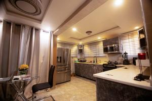 a kitchen with a refrigerator and a counter top at Classic Apartment at Tema Community 26 in Tema +14 photos