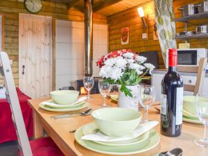 a dining table with a bottle of wine and glasses at Robin's Lodge in Westward