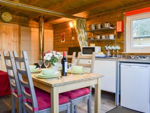 a kitchen with a wooden table with chairs and a tableablish at Robin's Lodge in Westward +10 photos
