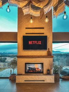 a fireplace in a living room with a netflix sign at Aftăr Hills in Poiana Mărului