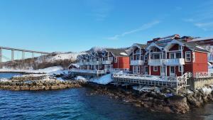 a row of houses on a pier next to the water at Tjeldsund Rorbu in Steinsland