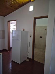 a white refrigerator in a room with a shower at Dos habitaciones Cómodo Residencia in Encarnación