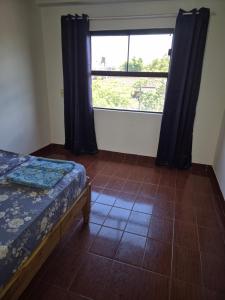 a bedroom with a bed and a large window at Dos habitaciones Cómodo Residencia in Encarnación