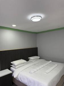 a bedroom with a large bed with white sheets and pillows at Petron home in Kempton Park