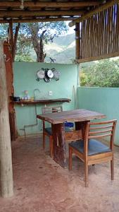 a wooden table and a bench and a table and chair at Colinas do braga chalés in Brumadinho