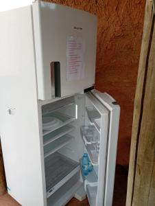 a white refrigerator with its door open with its door open at Colinas do braga chalés in Brumadinho