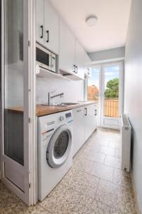 a kitchen with a washing machine and a sink at Villa Atol in Niechorze