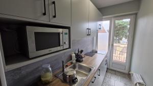 a kitchen with a sink and a microwave at Villa Atol in Niechorze
