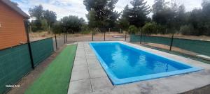 a swimming pool in front of a fence at Quillon cabañas in Quillón
