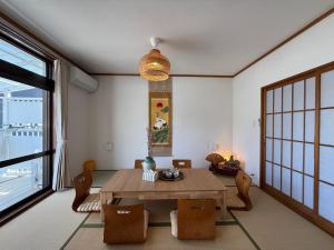 a dining room with a wooden table and chairs at 禅 宮島 一棟貸し 最大6名 ダブルベット3台 2階建の1棟貸しホテル in Hatsukaichi
