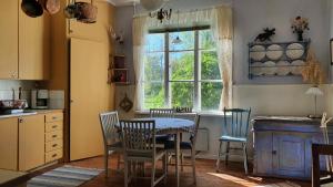 a kitchen with a table and chairs and a window at Lägenhet Strömsberg C in Strömsberg