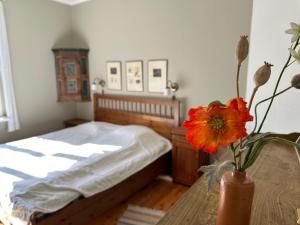 a bedroom with a bed and a vase with a flower on a table at Lägenhet Strömsberg C in Strömsberg