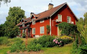 a large red house with flowers in front of it at Lägenhet Strömsberg C in Strömsberg