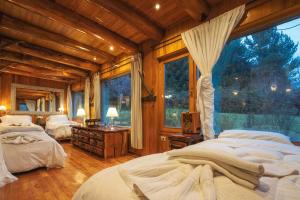 a bedroom with two beds and a large window at Rotui Luxury Village in San Martín de los Andes +89 photos