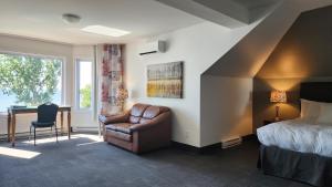 a bedroom with a bed and a chair and a desk at L'Auberge Du Lac St-Pierre in Trois-Rivières +46 photos