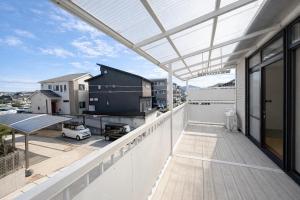 an outdoor balcony with a glass roof at 禅 宮島 一棟貸し 最大6名 ダブルベット3台 2階建の1棟貸しホテル in Hatsukaichi