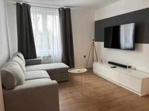 a living room with a couch and a tv at Clock in Gheorgheni