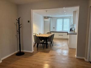 a dining room with a table and chairs and a kitchen at Clock in Gheorgheni