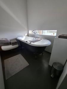 a bathroom with a tub and a toilet and a sink at B&B Finis terrae with wellness in Lokeren +103 photos