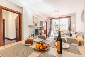 a living room with a table with a bottle of wine at BoLina Caniço Center in Caniço