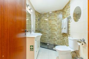 a bathroom with a toilet and a sink and a shower at BoLina Caniço Center in Caniço +28 photos