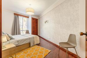 a bedroom with a bed and a table and chairs at BoLina Caniço Center in Caniço