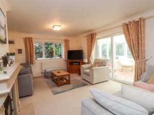 a living room with couches and a tv at Fernlea in Morfa Nefyn