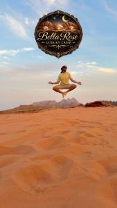 a person jumping in the air in the desert at Wadi Rum Bella Rose Luxury Camp in Disah